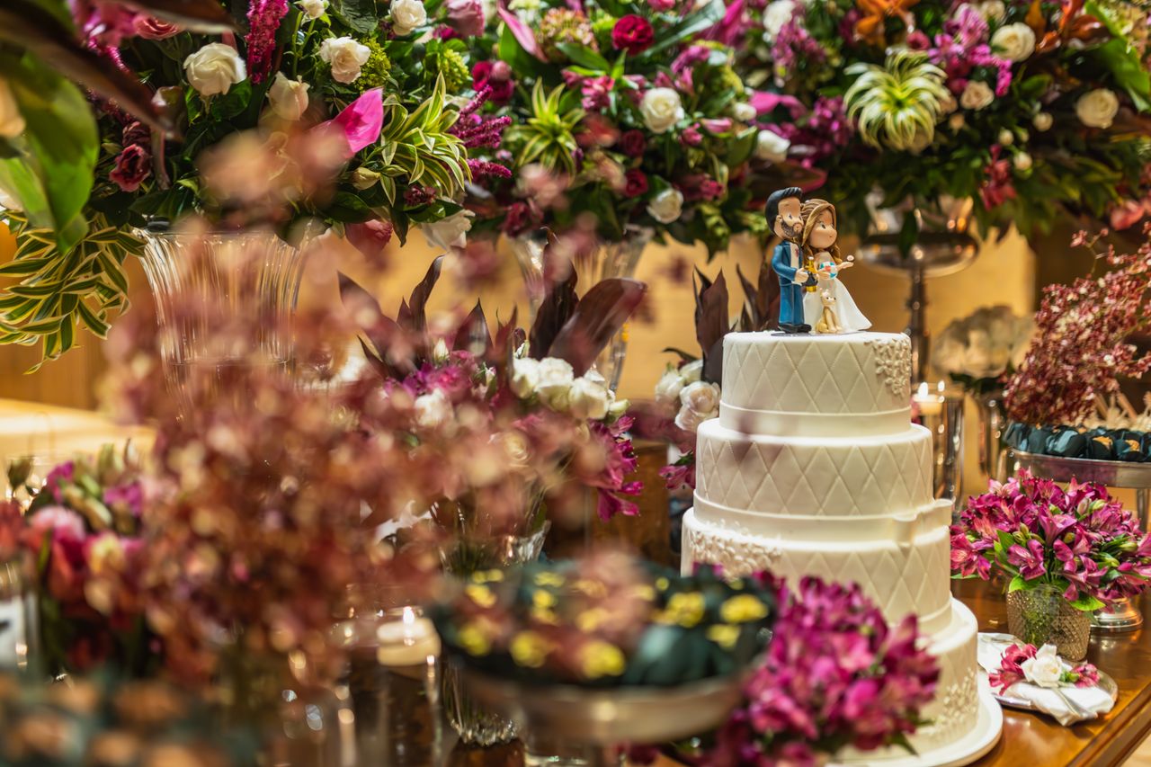 Celebrate special moments with this beautifully decorated wedding cake and floral arrangement.