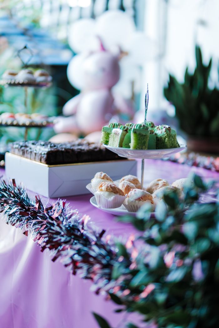 Vibrant party table setup with colorful cakes, pastries, and decorations in a festive setting.